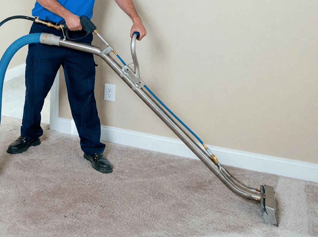 Professional operating a liquid removal machine on a carpeted floor in Jersey City, NJ