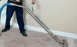 Professional operating a liquid removal machine on a carpeted floor in Jersey City, NJ